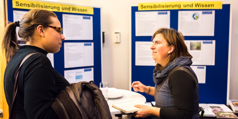Am Thementisch Sensibilisierung und Wissen tauschen sich Teilnehmende über Kooperationsmöglichkeiten zur Klimaanpassung in der Stadt Frankfurt am Main aus.