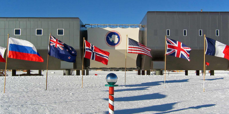 Am Südpol wehen die Flaggen der Erstunterzeichnerstaaten des Antarktis-Vertrages vor der amerikanischen Scott-Amundsen-Station.