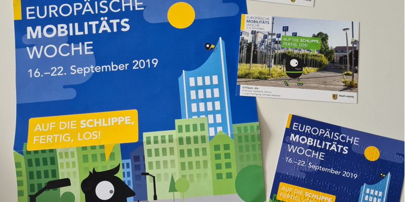 Plakate und Flyer der Fotoaktion in Leipzig "Auf die Schlippe, fertig, los!" und ein Flyer in Blindenschrift