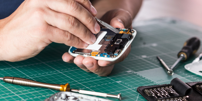 Mann repariert ein Smartphone