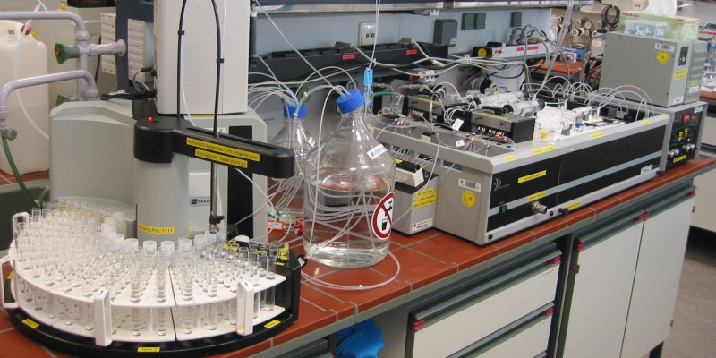 In einem Labor stehen auf einer Arbeitsplatte Analysegeräte und Behälter mit Flüssigkeiten