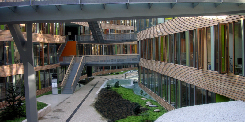 atrium with a glass roof, bridgesElongated inner courtyard with glass roof, skywalks linking two sides of the building, greenery and water basin