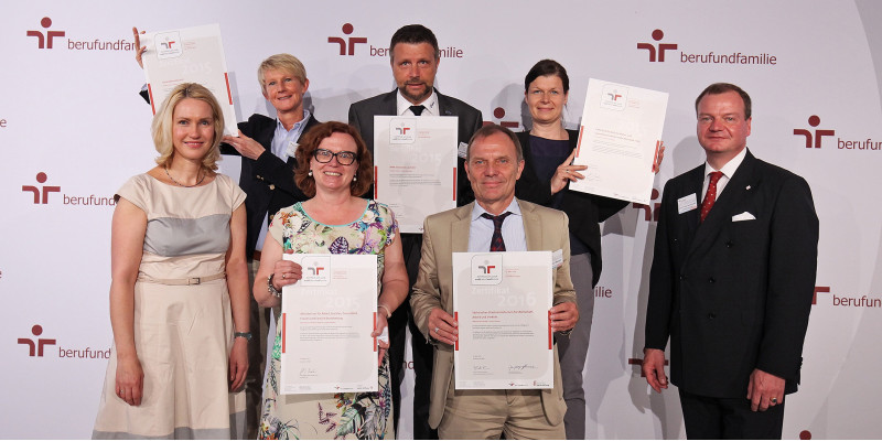 Gruppenfoto, die Personen halten das Zertifikat "Audit Beruf und Familie" 2015 in die Kamera
