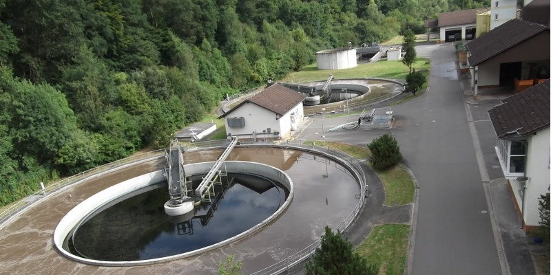 zwei Runde Wasserbecken einer Kläranlage am Waldrand