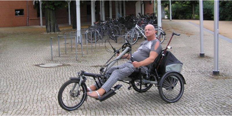 ein Mann auf einem Liegerad, welches sich mit den Armen statt mit den Beinen fortbewegen lässt
