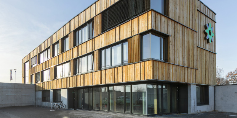 modernes 3-geschossiges Gebäude aus Holz und Glas mit Logo der Stadtwerke