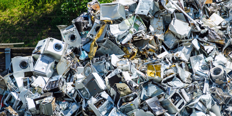old washing machines pile up at a recycling center
