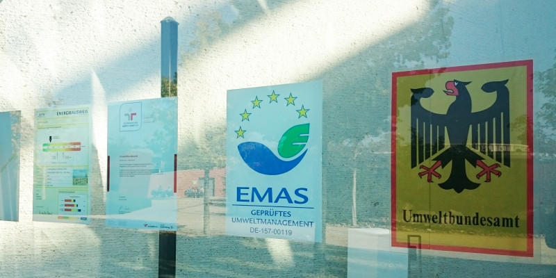 EMAS-Logo an der Glasfassade des Haupteingangs des UBA Dessau-Roßlau