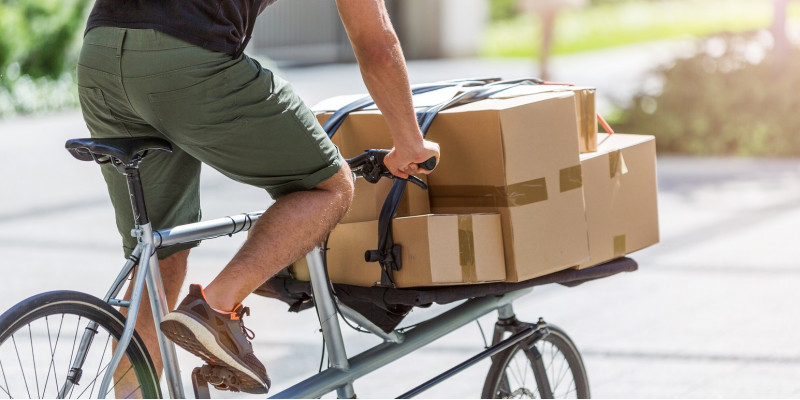ein Fahrradkurier transportiert Pakete und Päckchen auf einem Lastenrad