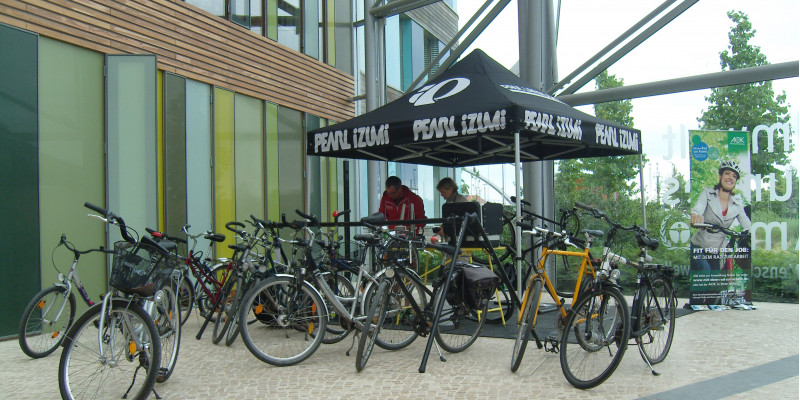 im Eingangsbereich des UBA-Dienstgebäudes Dessau werden Fahrräder repariert, im Hintergrund ein Werbeplakat für die Aktion "Mit dem Rad zur Arbeit"
