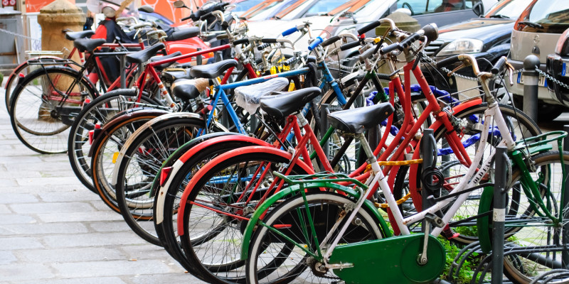 viele bunte Fahrräder in Fahrradständern abgestellt