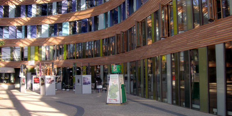 Der gepflasterte, mit Glas überdachte Eingangsbereich des UBA-Dessau-Roßlau mit Exponaten einer Ausstellung