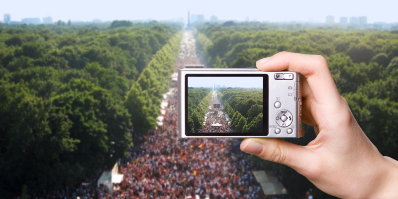 Digitalkamera fotografiert eine Großveranstaltung auf der Berliner "Straße des 17. Juni", rechts und links der baumbestandene "Große Tiergarten"