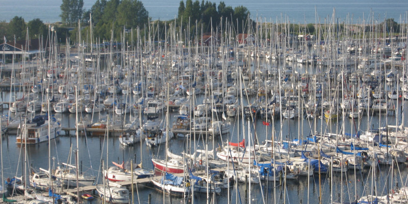 A sea harbor with many small sail and motor boats.