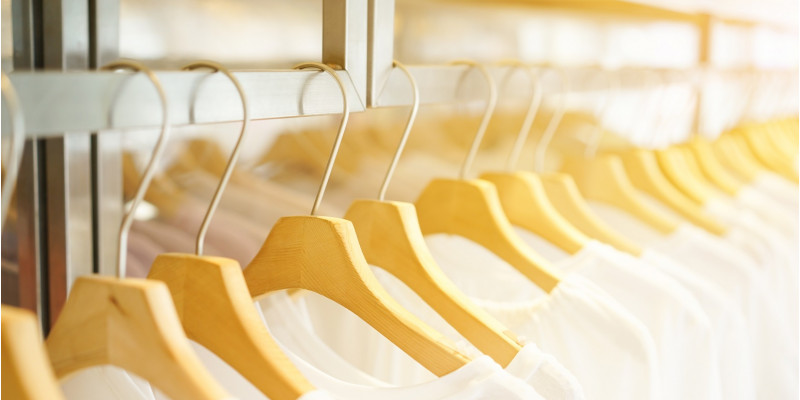in einem Geschäft hängen viele weiße T-Shirts auf Bügeln an einer Stange