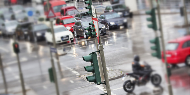 dicht befahrene Straßenkreuzung mit Ampeln, Autos und Motorrad