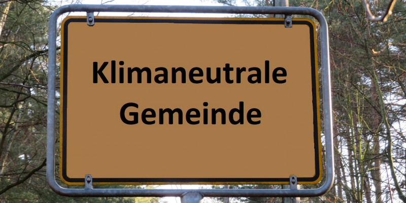 auf einem Ortsschild steht "Klimaneutrale Gemeinde"