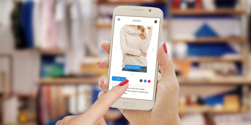 eine Frau schaut auf einem Smartphone Kleider in einem Onlineshop an