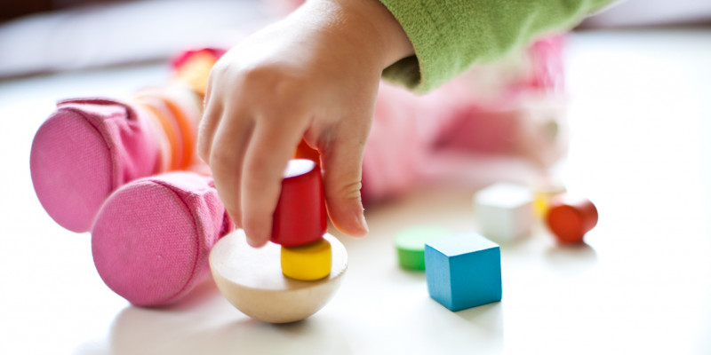 a child´s hand playing with toys