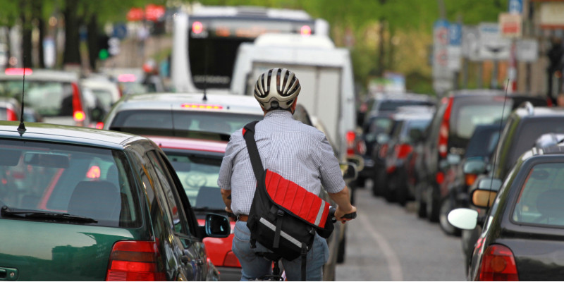 Radfahrer zwischen Autos im Stau