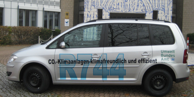 VW Touran car with the inscription "CO2-Klimaanlagen - klimafreundlich und effizient, R744" and the logo of the Umweltbundesamt