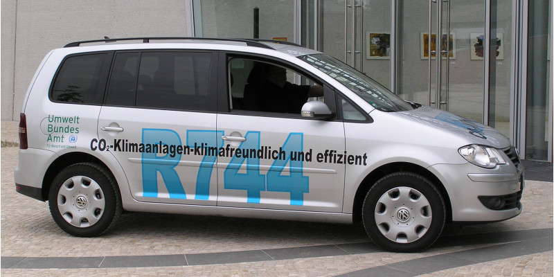VW-Auto mit der Aufschrift "R744, CO2-Klimaanlagen - klimafreundlich und effizient" und dem Logo des Umweltbundesamtes