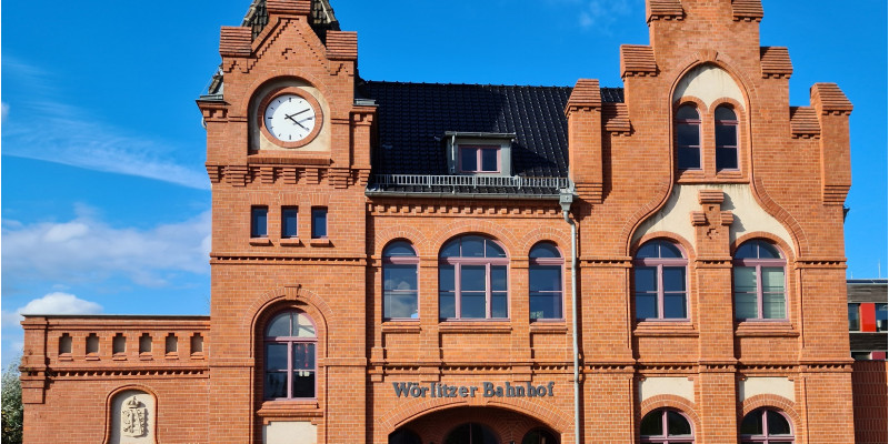 kleines, altes Bahnhofsgebäude aus rotem Backstein, über der Eingangstür der Schriftzug "Wörlitzer Bahnhof"