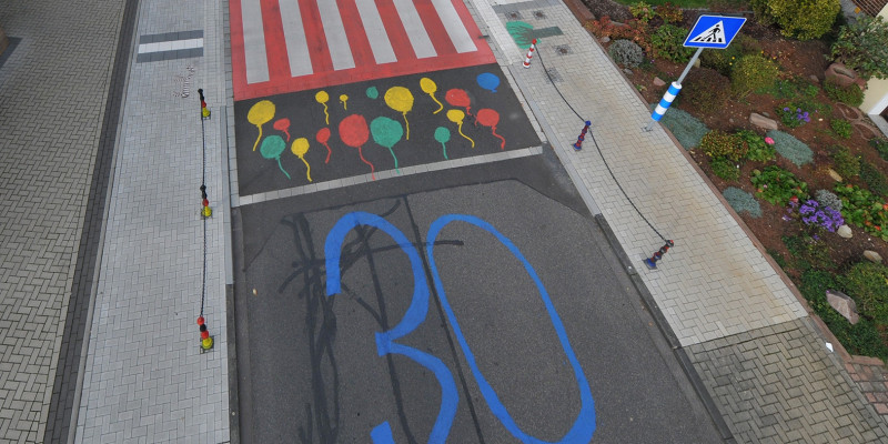 Blick auf die bunt gestaltete Kreuzung mit markierten Zebrastreifen und 30-er-Zone