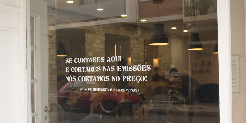 Aufschrift auf dem Schaufenster: „Ihr kommt mit dem Rad zu uns und senkt damit die Emissionen, dann senken wir den Preis Eures Haarschnitts“