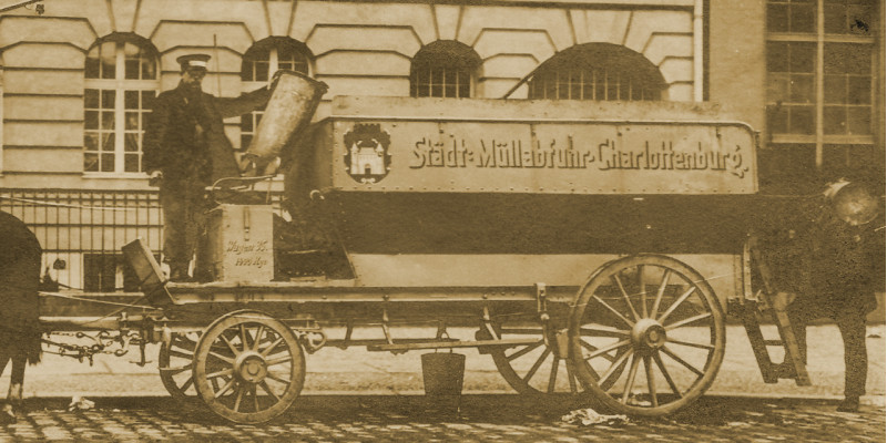 Zwei Arbeiter mit Pferdewagen sammeln Abfälle ein. 