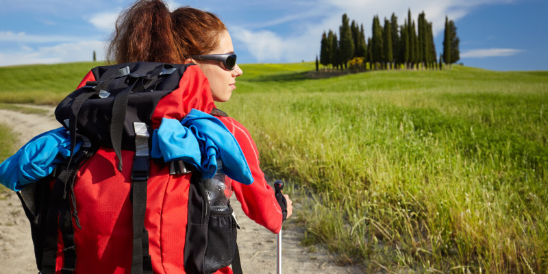 Frau mit Outdoorjacke und Rucksack beim Wandern