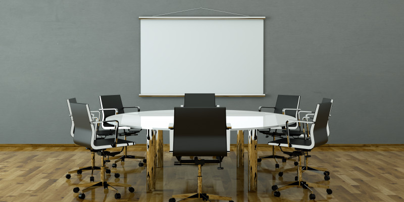 Konferenzzimmer mit hölzernem Bodenbelag, auf dem Tisch und Stühlen stehen