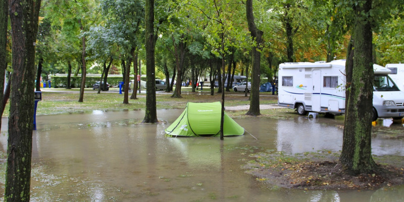 grünes Zelt im Wasser auf überflutetem Campingplatz