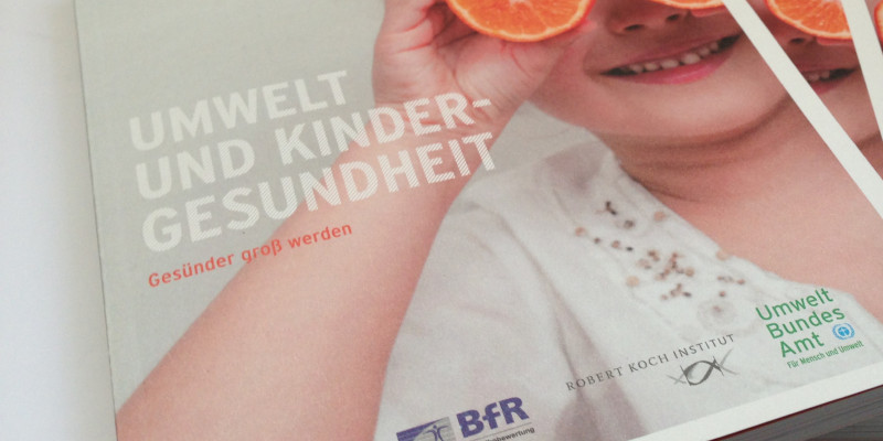 Cover der Broschüre mit einem Foto eines kleinen Mädchens, das sich aus Spaß zwei halbe Orangen vor die Augen hält