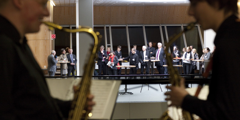 Zwei Saxophon-Spieler im Vordergrund, im Hintergrund der Empfang der Preisträger