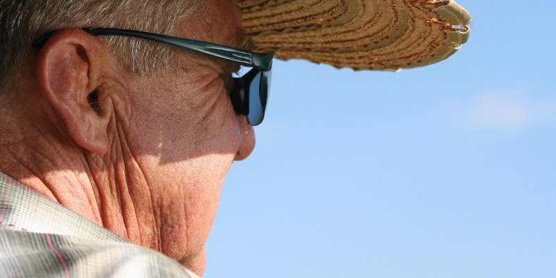 Älterer Mann mit Strohhut und Sonnenbrille
