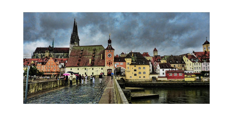 Blick auf Regensburg im Regen von einer Brücke.