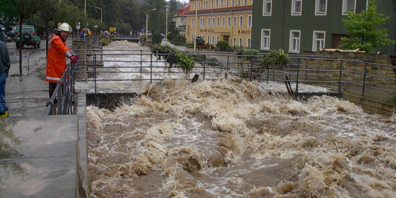 Ein Feuerwehrmann schaut zu wie braune Wassermassen abließen