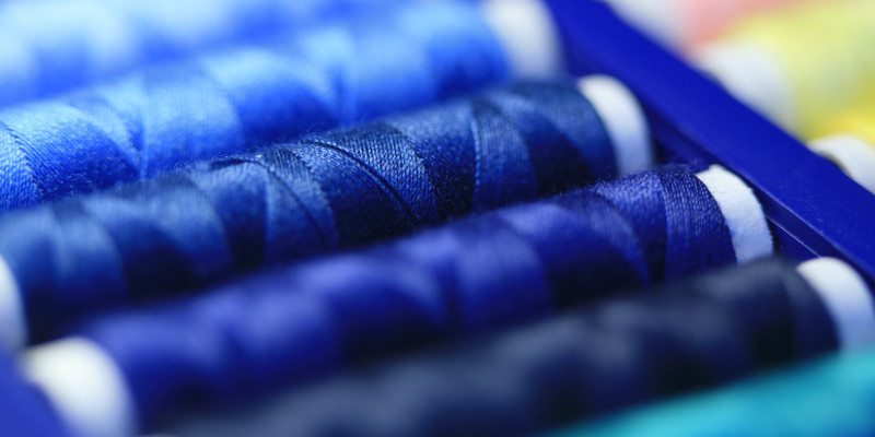 Eine Nahaufnahme von blauem Nähgarn auf Rollen