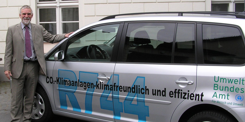 The former UBA´s President Jochen Flasbarth beside a silver VW Touran with the inscription "R744"