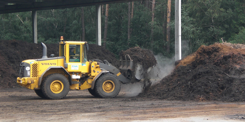 A yellow wheel loader implements composting in a composting plant.