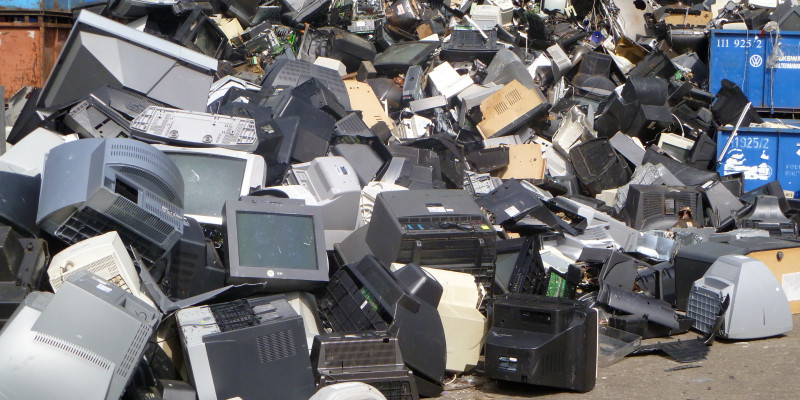 Old televisions and computer monitors on a pile.