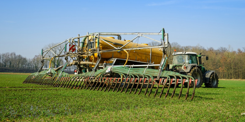 Ein Traktor bringt Gülle auf einem Feld aus