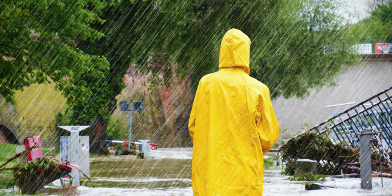 Eine Frau mit einer Regenjacke steht im Wasser.
