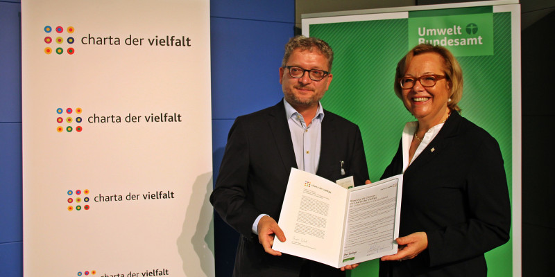 Zwei Personen mit der unterzeichneten Charta der Vielfalt