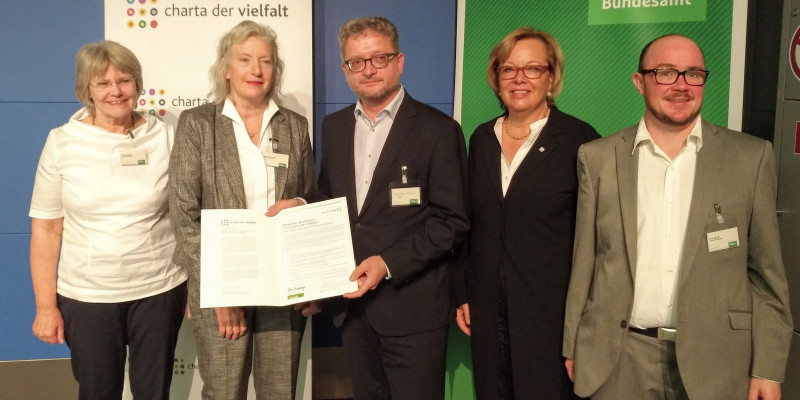 Fünf Personen mit der unterzeichneten Charta der Vielfalt.
