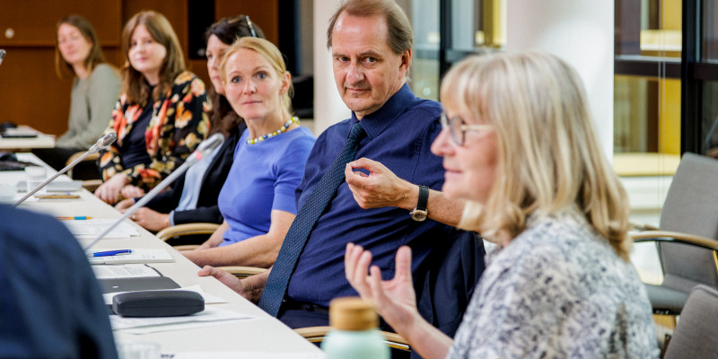 Das Bild zeigt mehrere Jurymitglieder, darunter den Präsidenten des Umweltbundesamtes Prof. Dr. Dirk Messner. Die Jurymitglieder sitzen auf ihren jeweiligen Plätzen und tauschen sich aktiv über die nominierten Projekte aus. 