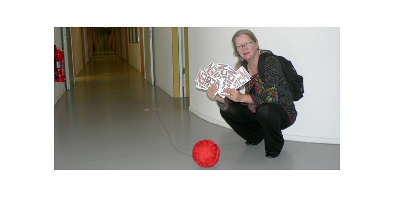 Christiane Keppler hockend mit Garnrolle & Schriftschablonen