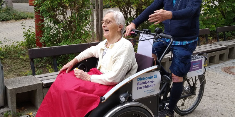 Seniorin lässt sich in Rikscha fahren