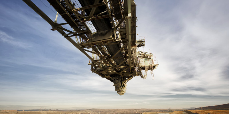 Stillstehender Schauffelradbagger auf einem Kohletagebau, man sieht bewölkten Himmel und den Tagebau, bei dem Kohle abgebaut wird